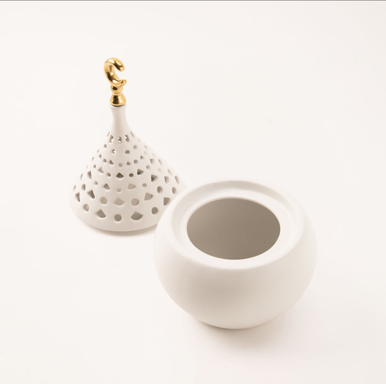 White ceramic hanging pot with gold hook on a white background